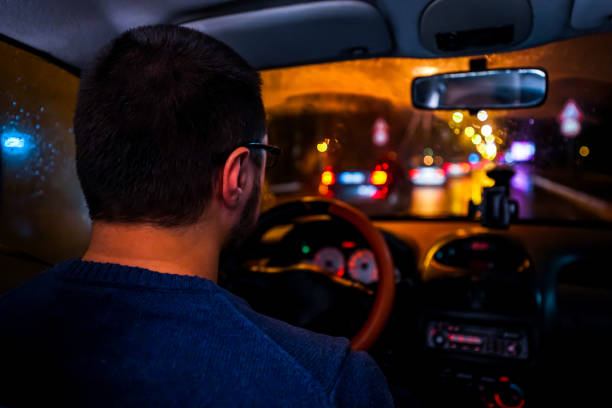 istock Man driving at night in the city 1196098781