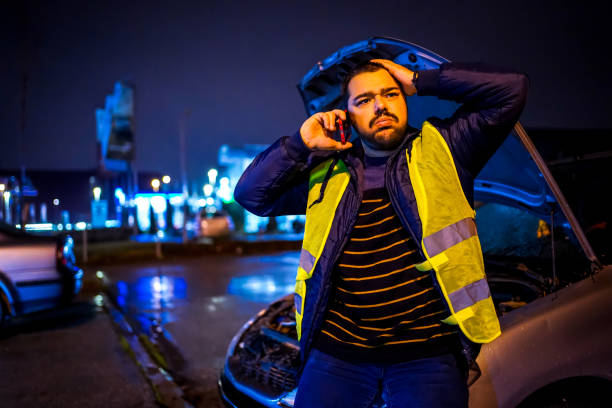istock Worried Man standing next to broken car 1196099059