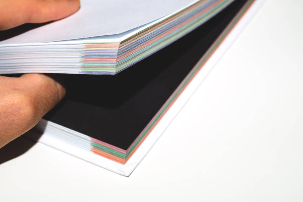istock Book is open on a black page. colorful book edge close up 1196100434