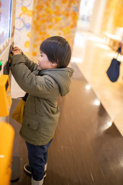 istock Little boy buying drink from vending machine 1196102136