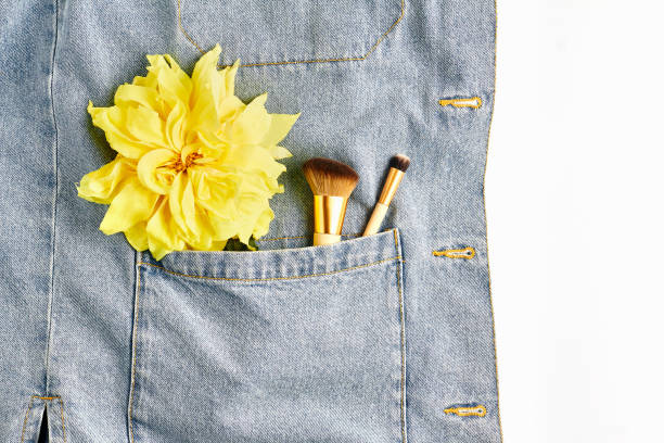 istock makeup brushes on denim background. creative concept. yellow Dahlia flower. top view, flat lay, copy space 1196107550