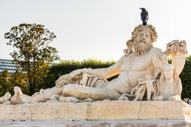 um corvo preto que está na estátua branca nos jardins de tuileries em paris - statue architecture sculpture formal garden - fotografias e filmes do acervo