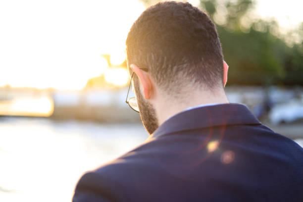 istock businessman thinking next to the sea at sunset time 1196108997