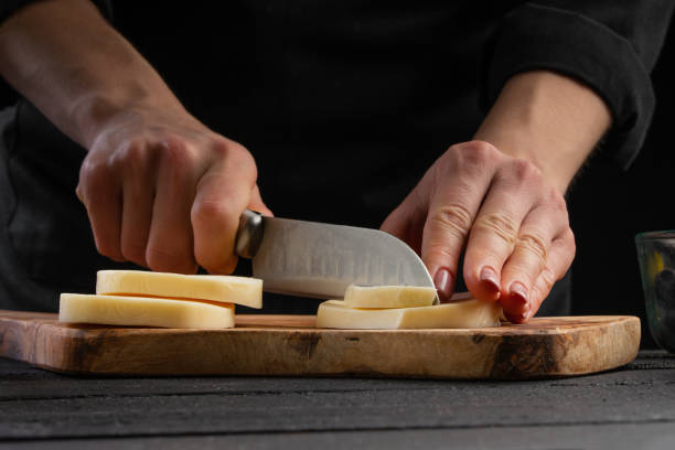 istock Professional chef slices cheese closeup, macro 1196109084