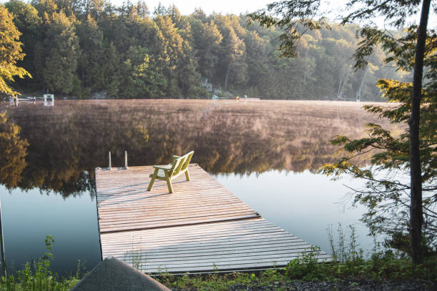 Toad Lake, ON 07/02/2019: Peaceful morning view of dock and misting lake in a Cottage country area of Ontario.
