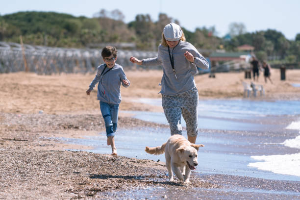 istock Happy mother and son running wit her dog 1196116915