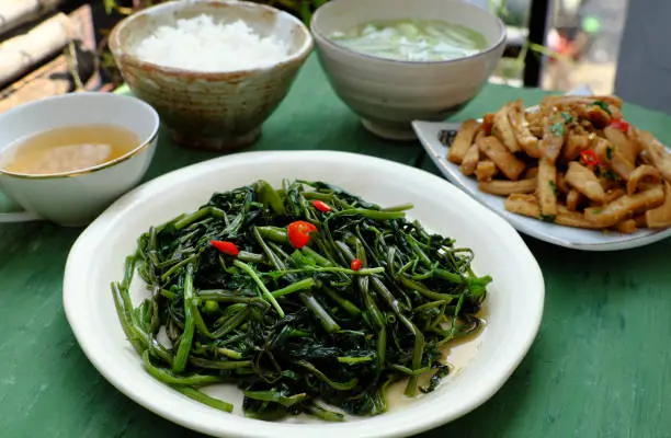 Simple vegan food for vegetarian meal, water spinach fry with cooking oil, delicious Vietnamese eating for daily family meal
