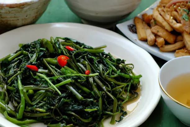 Simple vegan food for vegetarian meal, water spinach fry with cooking oil, delicious Vietnamese eating for daily family meal