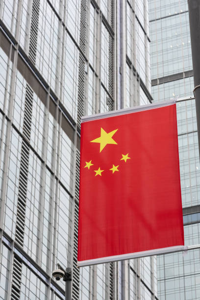 chinese flag against skyscraper facade stock photo