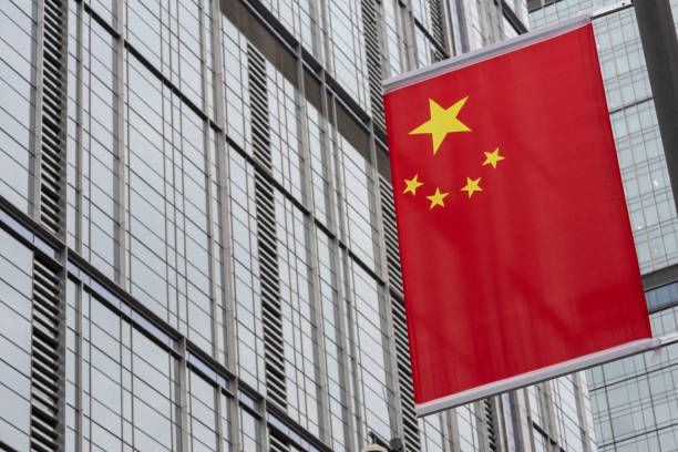 chinese flag against skyscraper facade stock photo