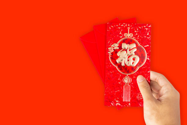 istock Translation text on red envelope in image: Prosperity and Spring. Hand Hold red envelope for Chinese New Year or Lunar New Year celebrations mean all things going smooth and well. 1196128247
