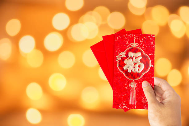 istock Translation text on red envelope in image: Prosperity and Spring.Hand Hold red envelope for Chinese New Year or Lunar New Year celebrations mean all things going smooth and well. 1196128257