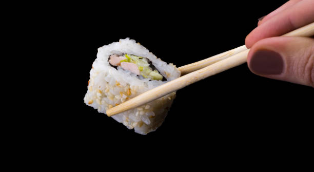 istock sushi rolls California in sesame on sticks on a black background 1196131847