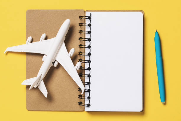 istock Toy plane with a notebook on a yellow background, top view. Flight planning concept 1196144022