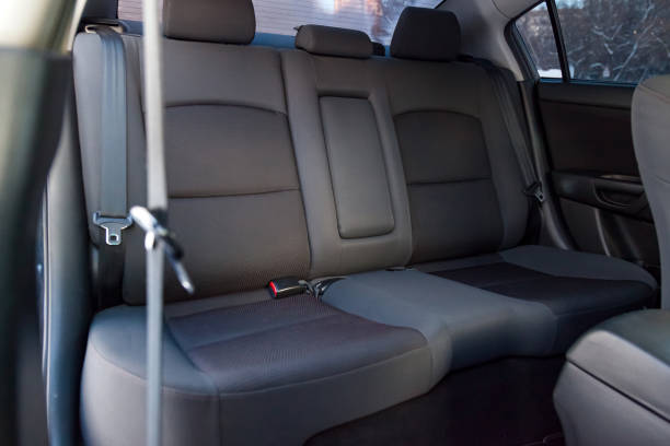 Close-up on rear seats with velours fabric upholstery in the interior of an old Japan car in gray after dry cleaning. Auto service industry. Close-up on rear seats with velours fabric upholstery in the interior of an old Japan car in gray after dry cleaning. Auto service industry. saloon car stock pictures, royalty-free photos & images