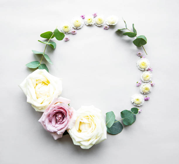 istock Decorative circle frame with pink and white roses and leaves on white background. Flat lay 1196145433