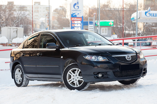 Novosibirsk, Russia - 12.26.2019: Black Mazda 3 2008 year front view with dark gray interior in excellent condition in a parking space among other cars