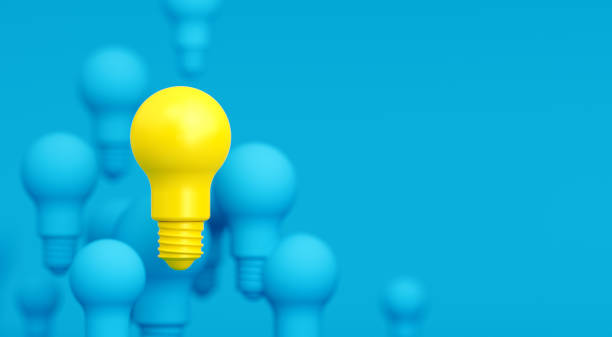 istock Blue and Yellow Light Bulbs over Blue Background 1196145528