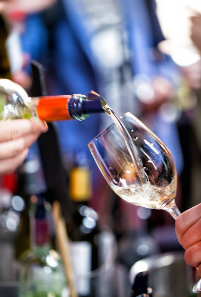 istock White wine is poured into a glass. Festive party 1196148040