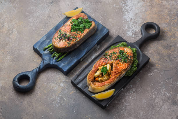 istock Two salmon steaks with vegetables on wooden boards, copy space 1196148914
