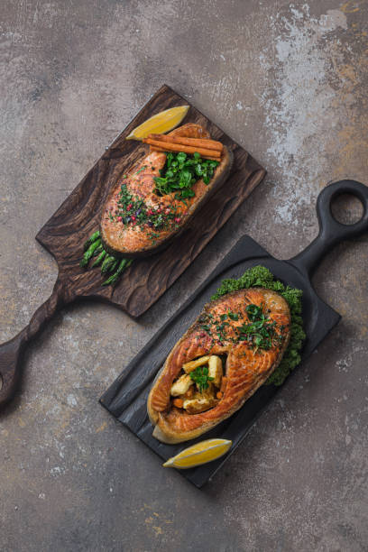 istock Two salmon steaks with vegetables on wooden boards, copy space 1196148932