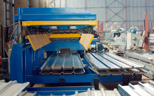 Bending machine for corrugated metal sheets in the production plant The industrial device for corrugated metal sheets bending by high precision machine in factory. Blue line machine conveyor for cutting sheet metal in mechanical workshop. crane machinery photos stock pictures, royalty-free photos & images