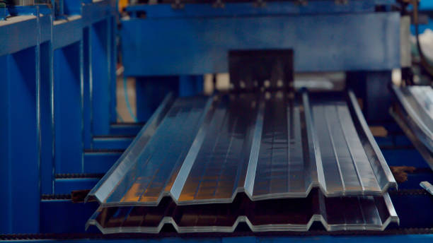 Bending machine for corrugated metal sheets in the production plant The industrial device for corrugated metal sheets bending by high precision machine in factory. Blue line machine conveyor for cutting sheet metal in mechanical workshop. Concept for metalwork production. sandwich panel photos stock pictures, royalty-free photos & images