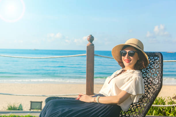 istock Woman in hat relaxing on beach 1196153235