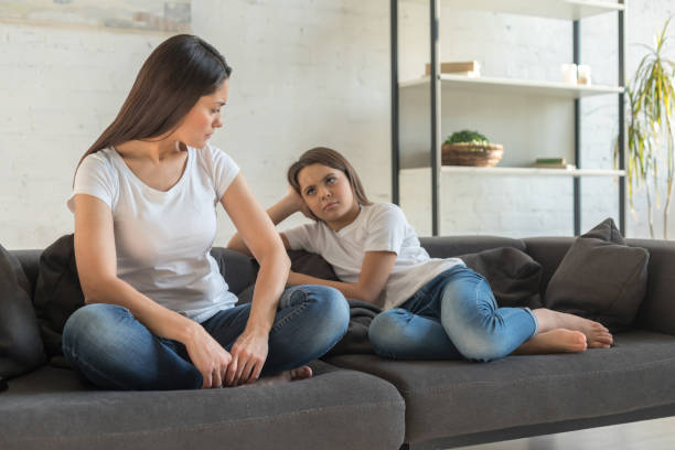 istock Child and mother sitting on sofa not talking 1196161039