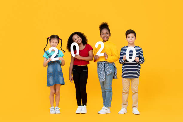istock Cute mixed race kids smiling and holding 2020 numbers 1196161408