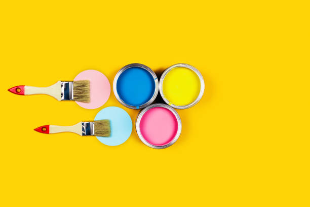 istock Yellow background with color paint jars and brushes 1196164629