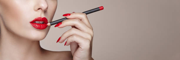 istock Beautiful woman paints lips with lipstick 1196167538