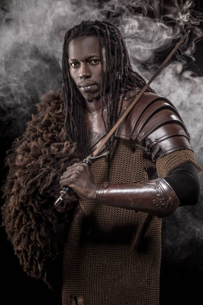 Portrait of a weapon wielding viking inspired black warrior in smoky studio shot