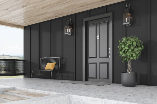 istock Black door of black house, tree and bench 1196169722