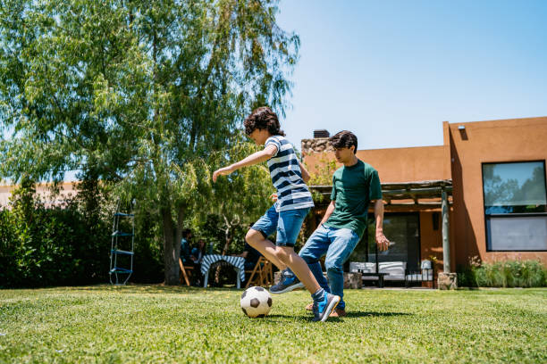 istock Kids playing football in backyard 1196170841