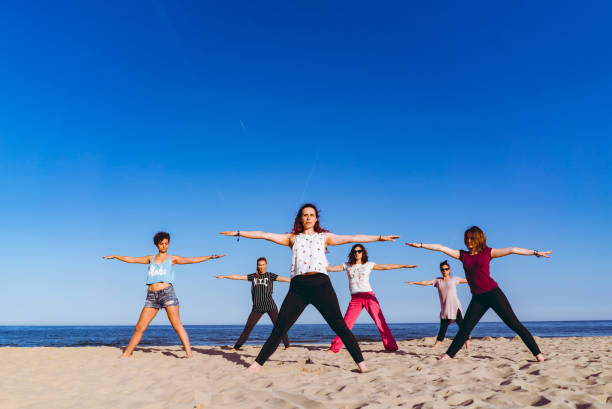 istock Group yoga on the beach 1196171587
