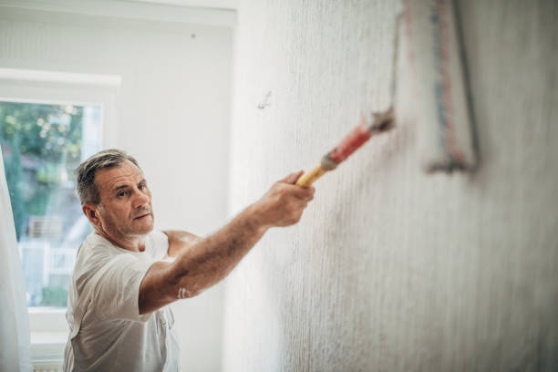 istock Professional painter worker is painting one wall 1196172438