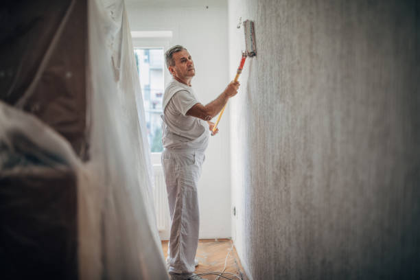 istock Professional painter worker is painting one wall 1196172445