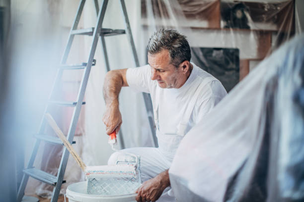 Man ready to paint wall holding painting tools