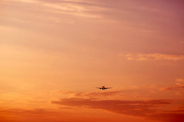 istock Airplane taking off and flying high in sunset sky 1196176730
