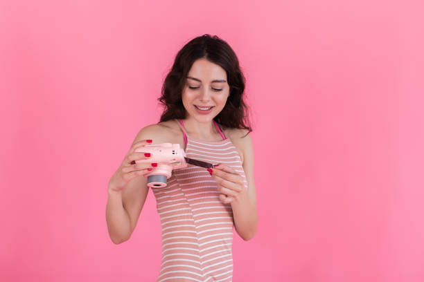 Young brunette girl looks at a picture taken on an instant camera stock photo