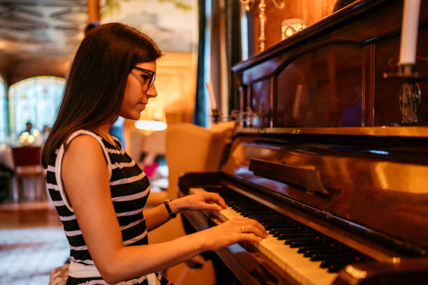 istock Young woman playing piano 1196176824