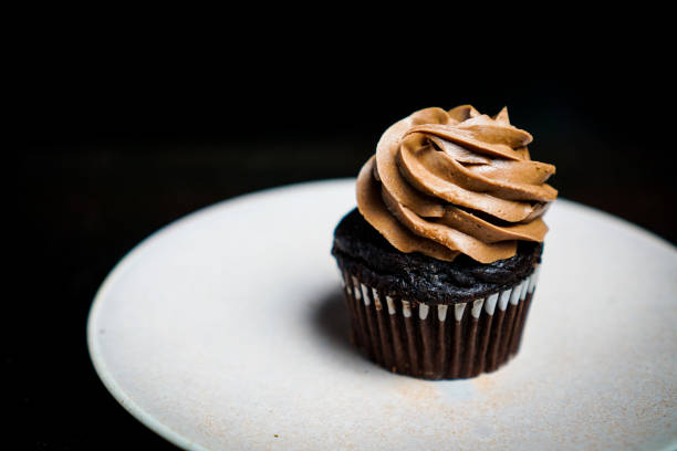 istock Chocolate cupcake with chocolate frosting on a plate 1196178721
