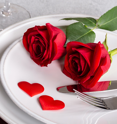 Closeup of Two Red Roses on a table setting for Valentines Day