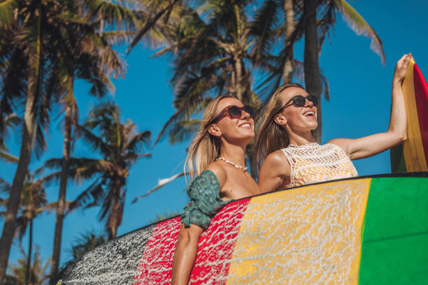 istock Young ladies with surfboards going surfing 1196186391