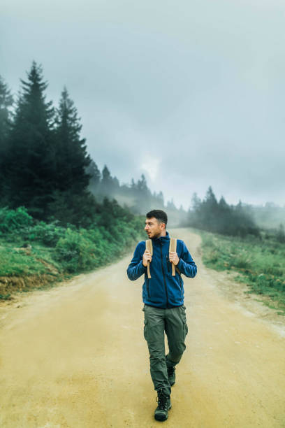 istock young man doing trekking on foggy forest road 1196187034