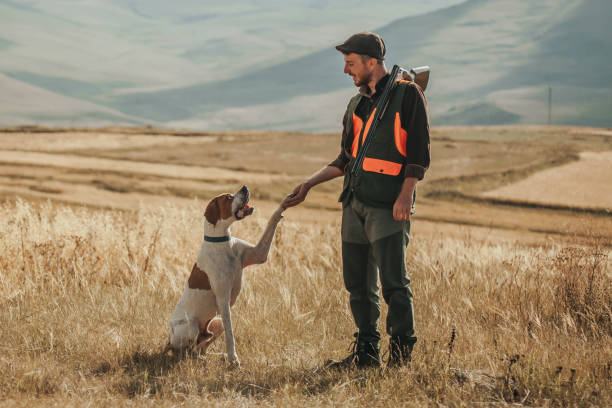young hunter holding hands with his dog