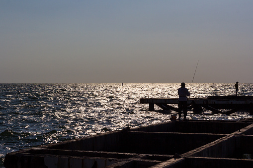 a man fishing by the sea.