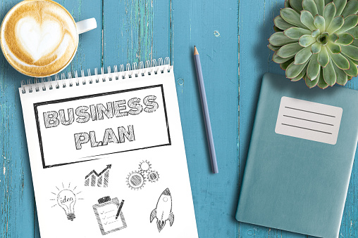 concepto de estrategia de negocio, vista superior del plan de negocios en el bloc de notas sobre la mesa de madera photo