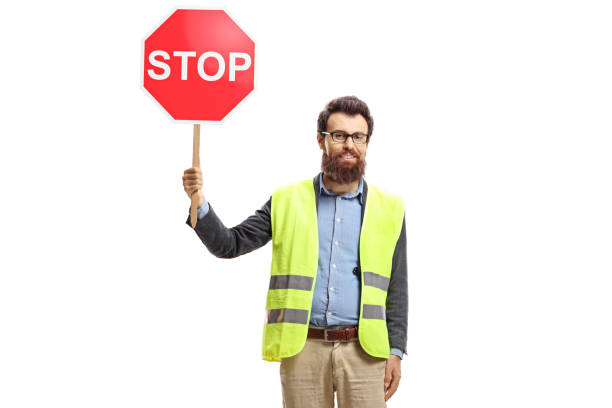 istock Bearded man with a safety vest holding a stop sign 1196199142